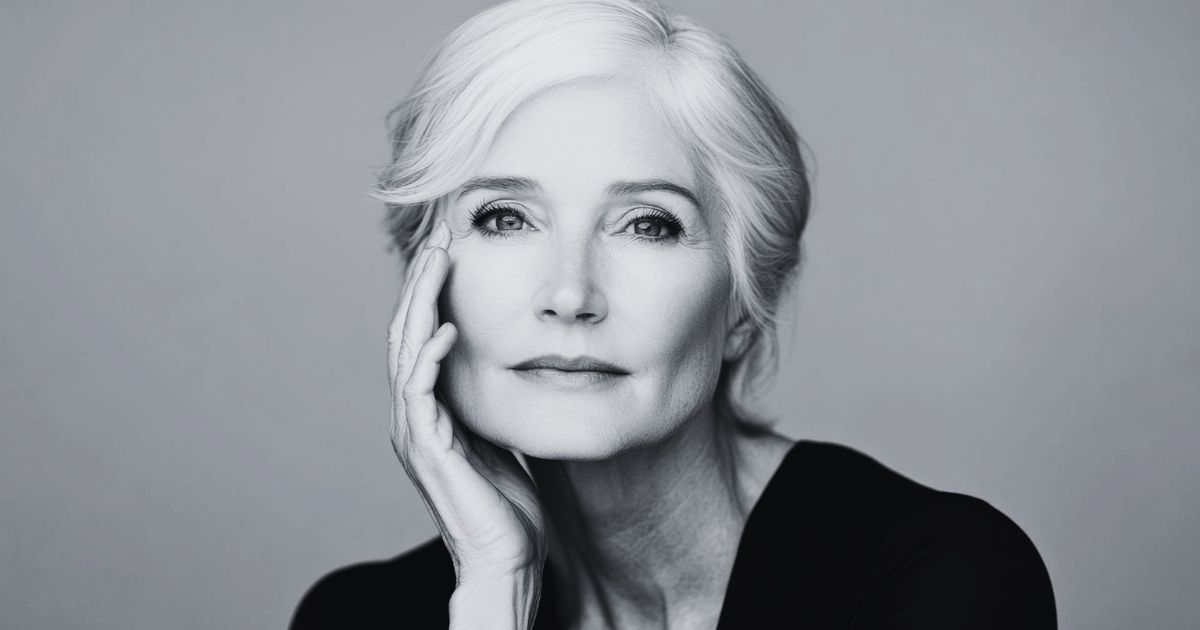 Blog 6 Black-and-white portrait of a mature woman with short silver hair gently touching her face.