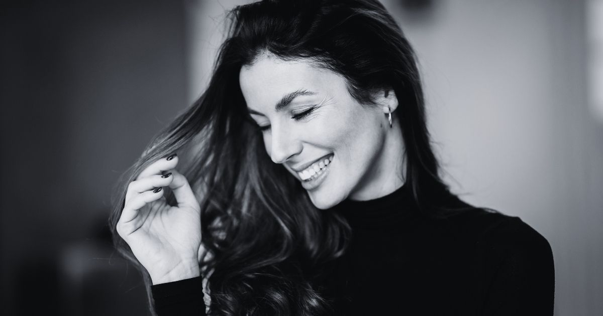Blog 3 Smiling woman with long dark hair in a black top.